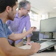People-two-men-looking-at-a-screen