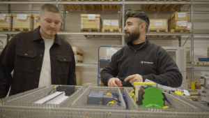 Två män från Domino står vid en elinstallation 